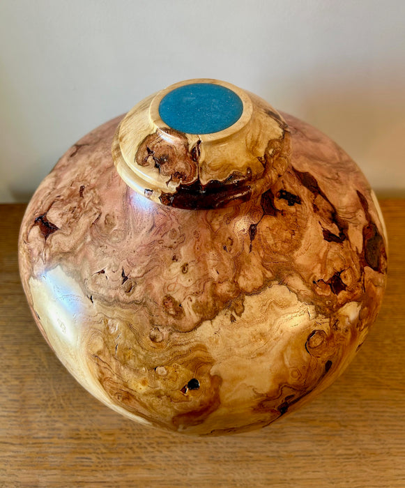 Burled cherry turned urn with sky blue epoxy filled lid